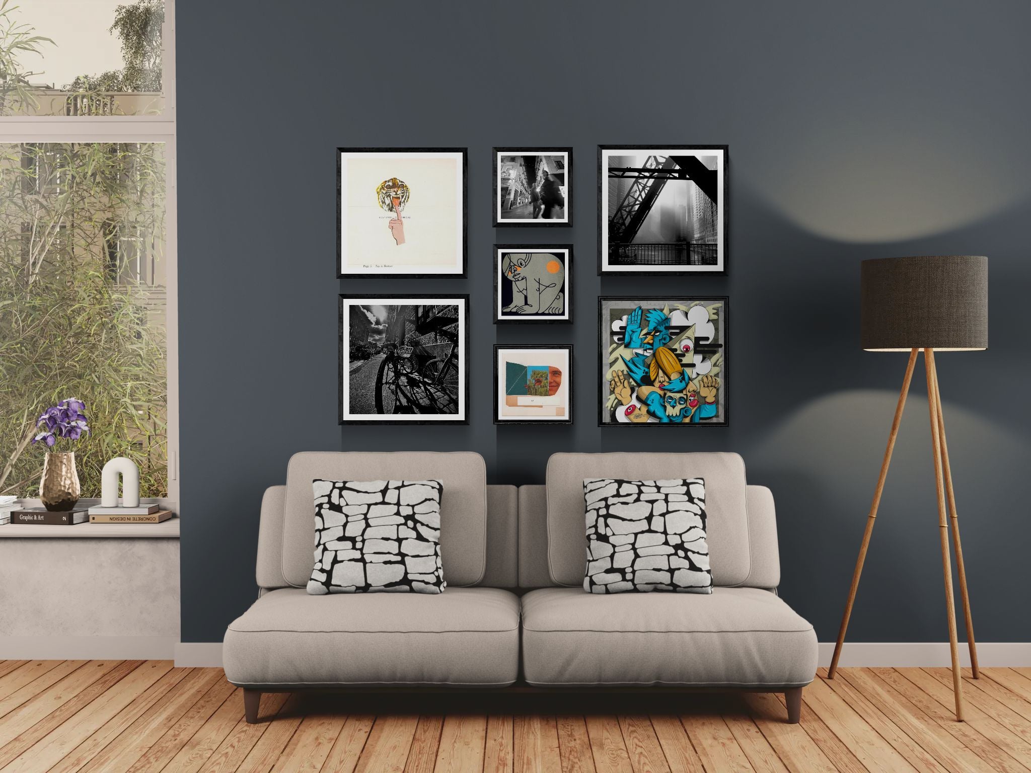 Modern living room with a gray sofa, decorative pillows, and framed art on a dark blue wall.