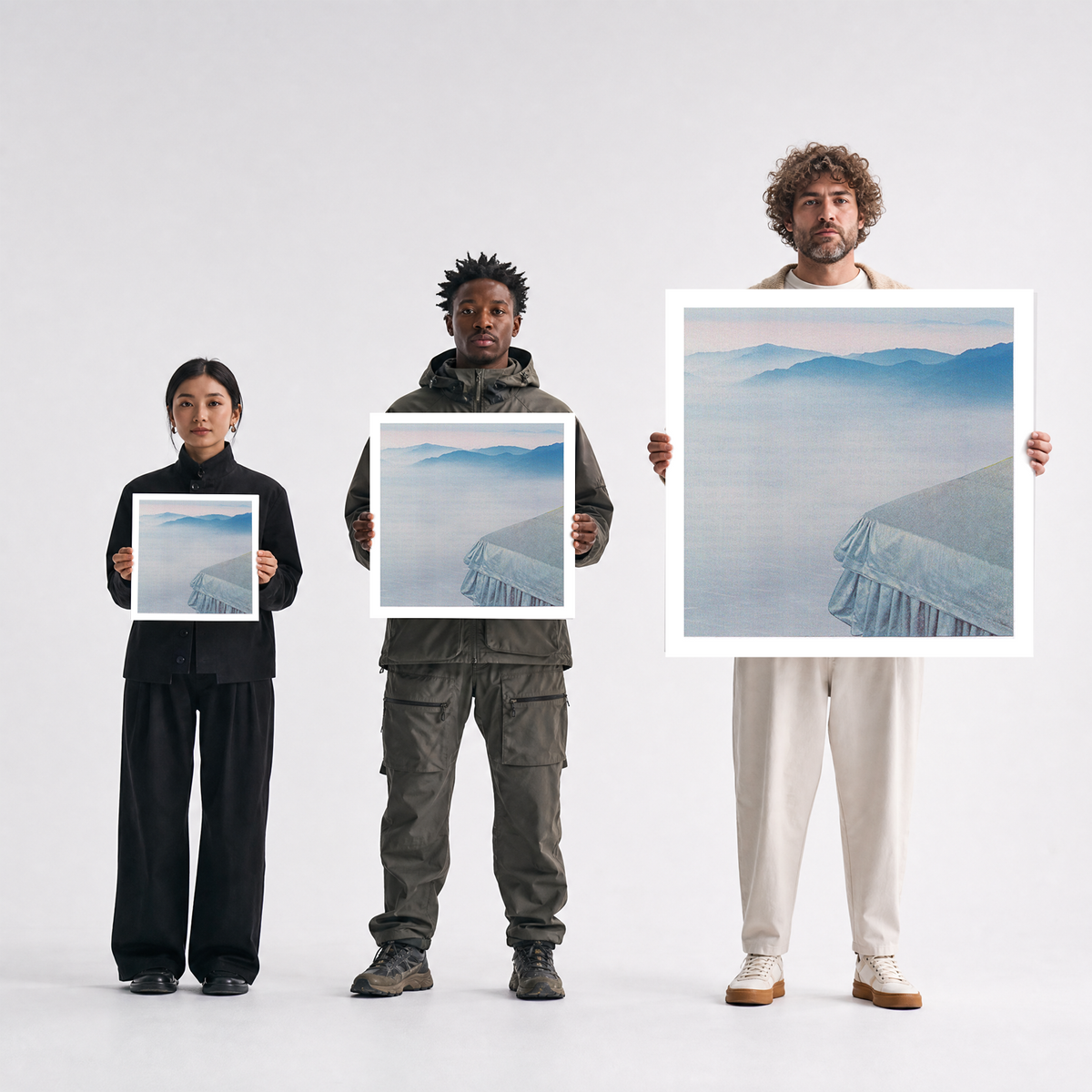 Scale comparison photo showing the 12x12, 20x20, and 40x40 print sizes of 'Cerulean' by Sunday Morning, held by three models for size reference.