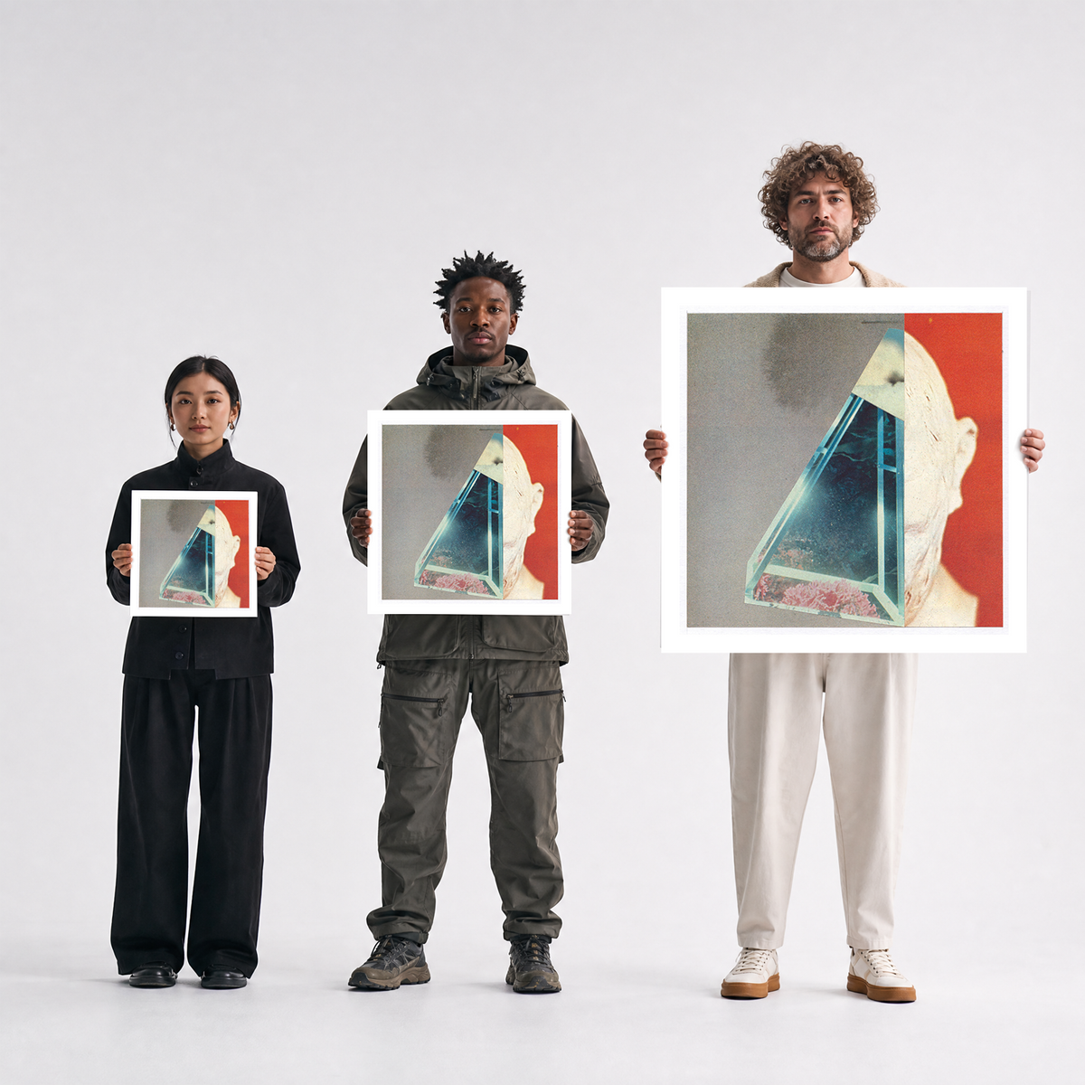 Three people standing against a light gray studio background, each holding a square art print featuring a surreal triangular glass-like object over a red and off-white portrait.